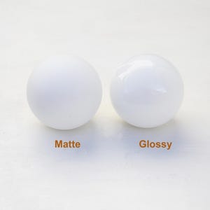 May include: Two white spheres, one with a matte finish and the other with a glossy finish. The spheres are labeled "Matte" and "Glossy".