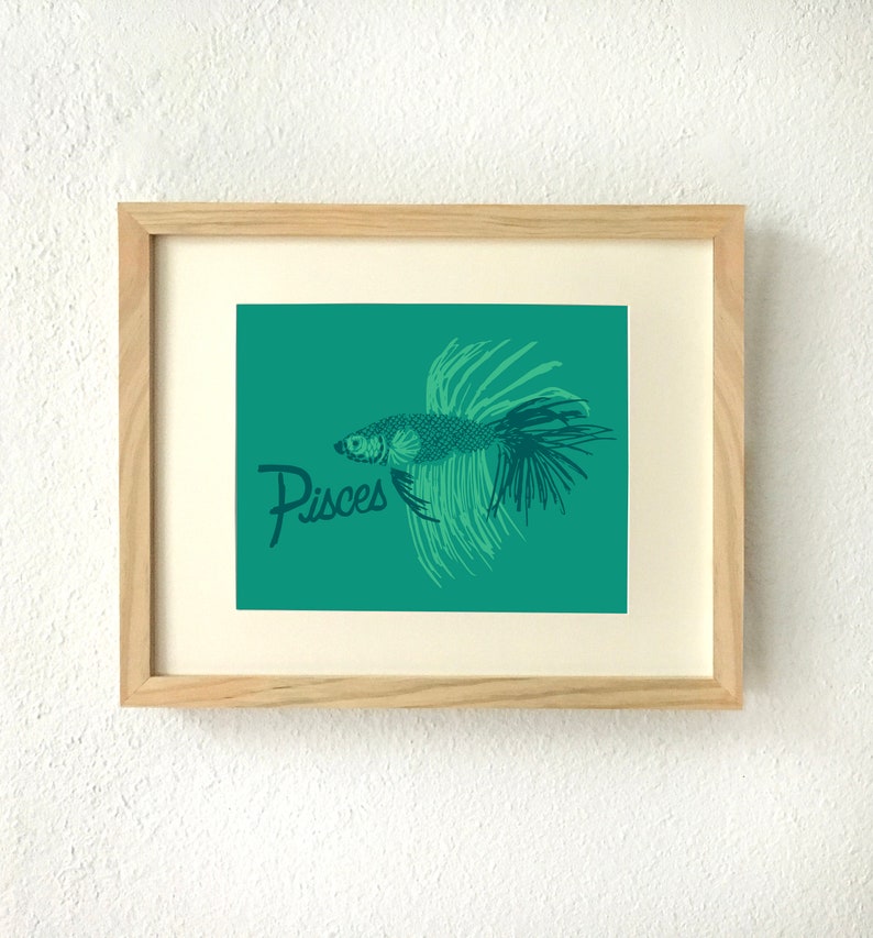 May include: A teal green framed print with a black and green illustration of a fish with the word "Pisces" in a cursive font.
