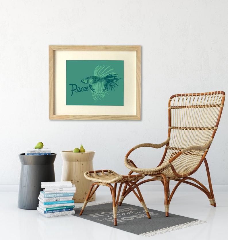 May include: A framed print with a teal background featuring a stylized illustration of a fish with the word "Pisces" in dark blue lettering.