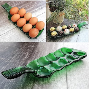 Pode incluir: Uma garrafa de vidro verde reutilizada como prato de servir com seis seções rebaixadas. O prato está cheio de doces de chocolate e ovos.
