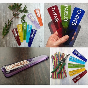 May include: Assortment of colorful glass plant markers with white lettering. The markers are labeled with the names of herbs, including Chives, Parsley, Thyme, Basil, Mint, and Coriander.