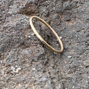 K&ouml;nnte beinhalten: Ein einfacher Goldring mit geh&auml;mmerter Textur.