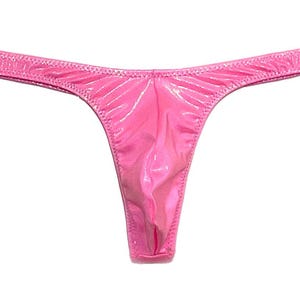 May include: A bright pink thong underwear with a shiny, smooth texture. The garment has a low-rise waist and a narrow thong back. The edges are finished with a delicate stitching.