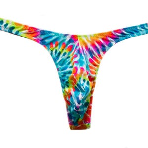 Op de afbeelding: Een string met een levendig tie-dye patroon met heldere wervelingen van blauw, geel, oranje en roze. Het kledingstuk heeft een dunne tailleband en een minimalistische snit, met een kleurrijk, meerkleurig ontwerp over het gehele oppervlak van de stof.