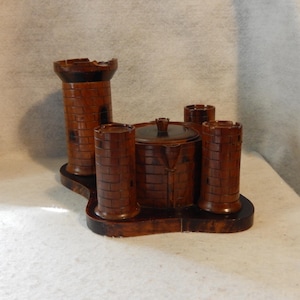 May include: A wooden castle-shaped trinket box with four towers and a removable lid. The box is made of dark wood and has a detailed design.