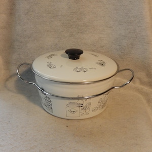 Puede incluir: Olla de esmalte color crema con tapa y pomo negro. La olla tiene un asa de metal y está decorada con dibujos lineales negros de verduras y artículos de cocina. Un encantador artículo de cocina vintage.