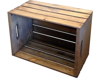 Könnte beinhalten: Rechteckige Holzkiste mit natürlicher Oberfläche. Die Kiste hat horizontale Lamellen an den Seiten und am Boden sowie eine Lamellenoberseite. Sie verfügt über Grifflöcher an den Seiten. Die Kiste ist aus hellbraunem Holz gefertigt.