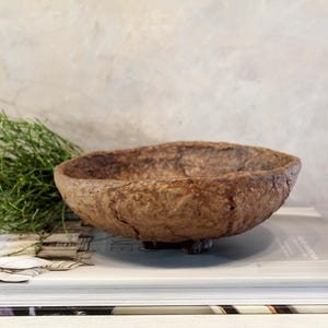 Ciotola di cartapesta su tre gambe in terracotta marrone, con piedini decorativi, strutturata, stile wabi sabi, rustico, primitivo, ispirato ai nomadi.