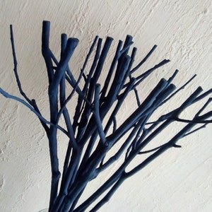 Peut inclure: Un bouquet de brindilles peintes en bleu fonc&eacute; dispos&eacute;es dans un vase. Les brindilles sont fines et ont un aspect naturel et rustique.