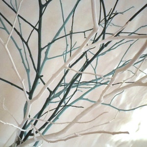 May include: White and teal painted branches arranged in a vase. The branches are intertwined and create a natural, organic look.