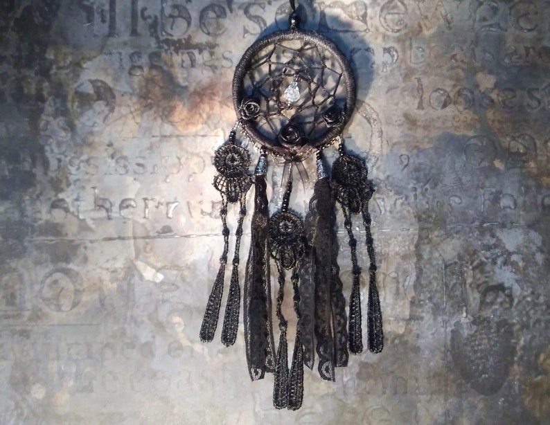 May include: Black dreamcatcher with beaded fringe and black feathers. The dreamcatcher has a crystal bead in the center and black roses around the outer edge.