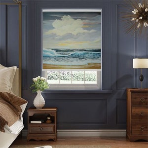 May include: A bedroom interior with a window featuring a roller shade with a seascape painting. The shade depicts a blue ocean with white waves crashing on a sandy beach. The room is painted a dark blue and features a wooden nightstand with a vase of white flowers.