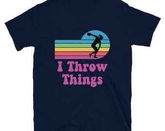 May include: Navy blue t-shirt with a rainbow stripe design and a silhouette of a person throwing a discus. The text "I Throw Things" is printed in pink below the design.