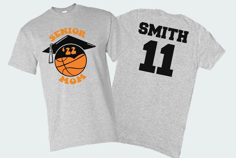 K&ouml;nnte beinhalten: Graues T-Shirt mit einem Basketball- und Abschlusskappen-Design, auf dem "Senior '22 Mom" steht. Auf der R&uuml;ckseite des Shirts steht der Name "Smith" und die Nummer "11" in Schwarz.