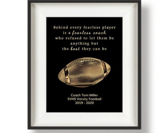May include: A black and gold framed print with a quote about fearless coaches and players. The quote reads "Behind every fearless player is a fearless coach who refused to let them be anything but the best they can be." The print also includes a gold football and the text "Coach Tom Miller SVHS Varsity Football 2019-2020".