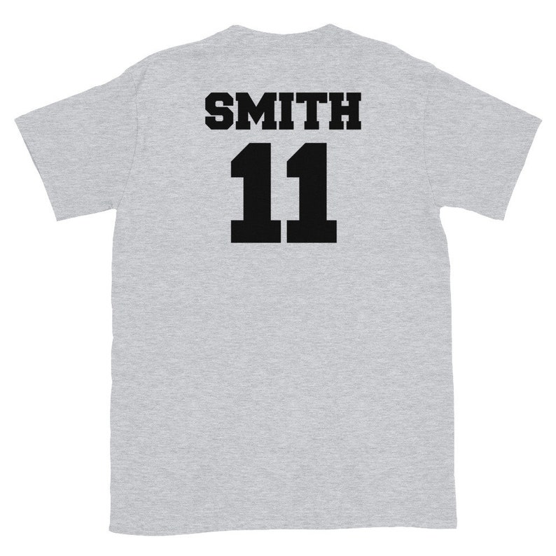K&ouml;nnte beinhalten: Graues T-Shirt mit schwarzem Text auf der R&uuml;ckseite, der "SMITH 11" lautet.