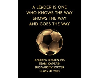 Könnte beinhalten: Ein schwarzes und goldenes Motivationszitat über Führung mit einer goldenen Fußballgrafik. Der Text lautet "Ein Leader ist einer, der den Weg kennt, den Weg zeigt und den Weg geht". Unter der Grafik steht der Text "Andrew Braten #15 Mannschaftskapitän BHS Varsity Soccer Klasse von 2023".