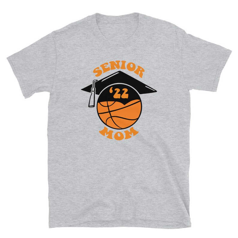K&ouml;nnte beinhalten: Graues T-Shirt mit einem Basketball, auf dem eine Abschluss-Kappe sitzt. Der Basketball ist orange und schwarz. Der Text "Senior '22 Mom" ist auf das T-Shirt gedruckt.