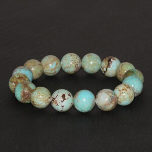 May include: A turquoise and brown beaded bracelet with round beads. The beads have a mottled pattern.