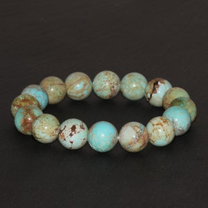 May include: A turquoise and brown beaded bracelet with round beads. The beads have a mottled pattern.