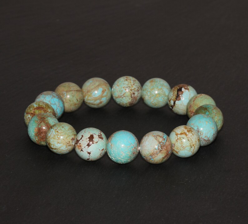May include: A turquoise and brown beaded bracelet with round beads. The beads have a mottled pattern.