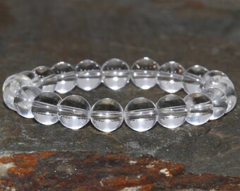May include: A clear quartz crystal beaded bracelet with round beads. The bracelet is made of natural stones and is a popular choice for meditation and healing.