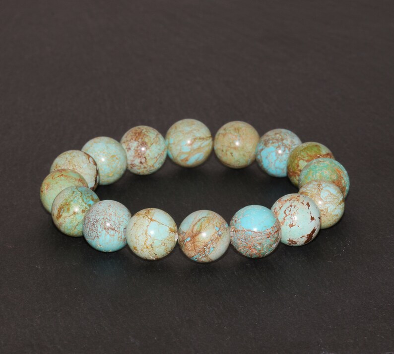 May include: A turquoise and brown gemstone bracelet with round beads. The bracelet is made of natural stones and has a unique, marbled pattern.