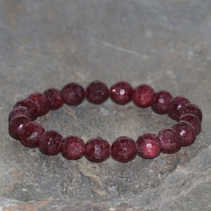 Peut inclure: Un bracelet en pierres précieuses rouges avec des perles facettées. Le bracelet est fait de pierres naturelles et est un beau bijou.