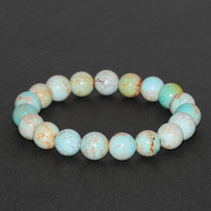 May include: A turquoise blue bracelet with gold flecks, made of round beads.