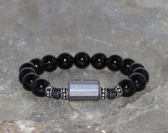 May include: A black onyx beaded bracelet with a silver hexagonal charm.