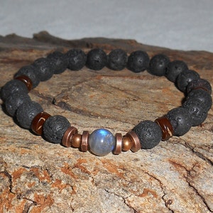 May include: A black lava rock bracelet with copper spacers and a blue labradorite gemstone bead.
