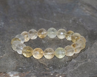 May include: A bracelet made of round, clear and yellow beads with a textured surface.