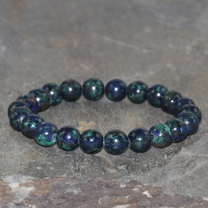 May include: A blue and green gemstone bracelet with round beads.