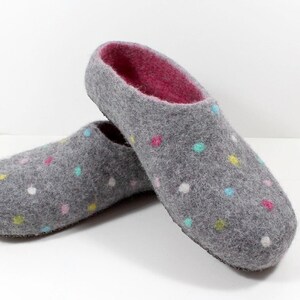 May include: A pair of gray felt slippers with a pink lining and colorful polka dots.