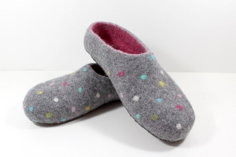 May include: A pair of gray felt slippers with a pink lining and colorful polka dots.