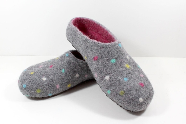 May include: A pair of gray felt slippers with a pink lining and colorful polka dots.