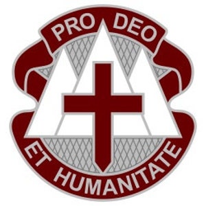 May include: A white patch with two red triangles and a red cross in the center. The patch has a maroon border with the words "Pro Deo et Humanitate" around the outside.