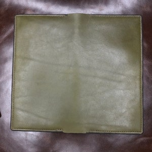 May include: A green leather wallet with a stitched edge.
