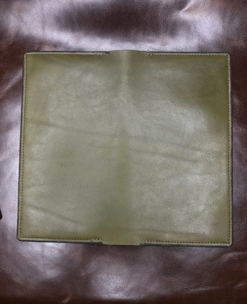 May include: A green leather wallet with a stitched edge.