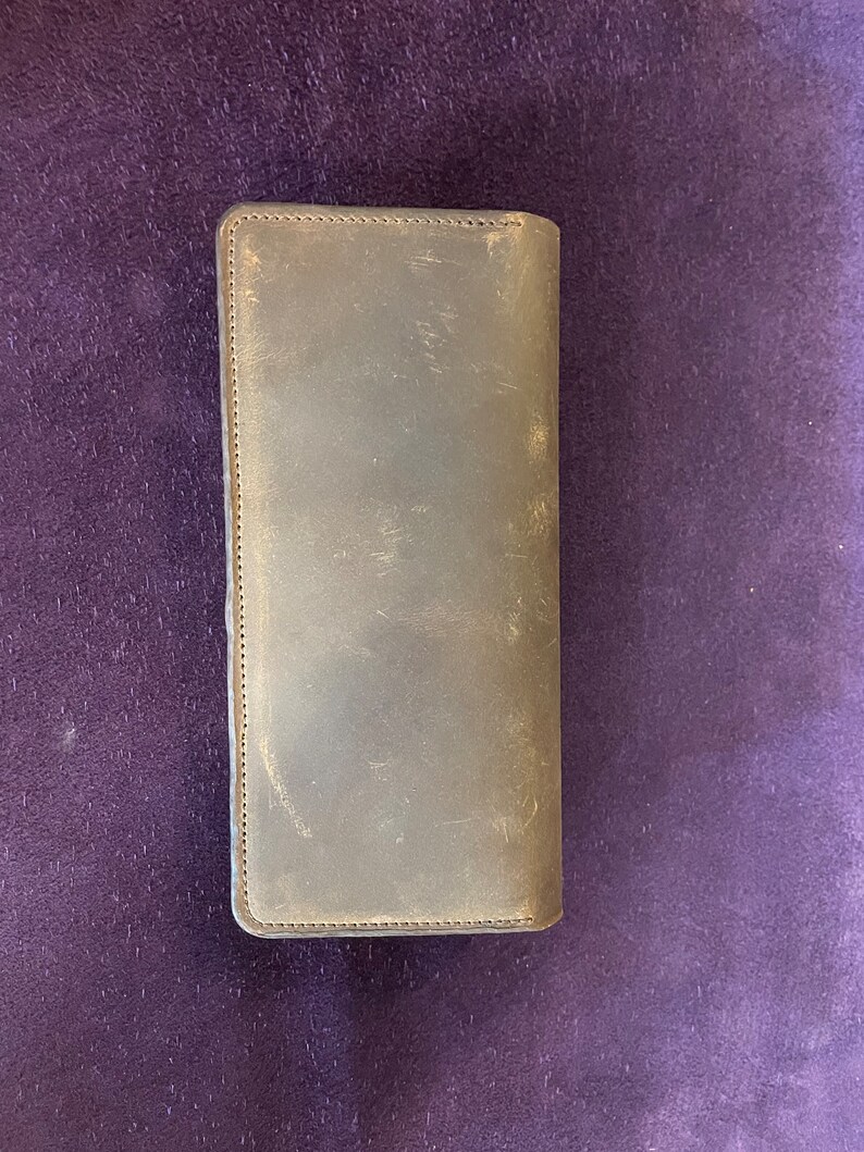 May include: A brown leather wallet with a stitched edge.