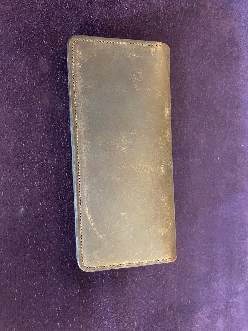 May include: A dark brown leather wallet with a stitched edge.