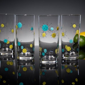 May include: Set of four clear glass highball glasses with a mid-century modern design featuring turquoise and yellow abstract shapes.