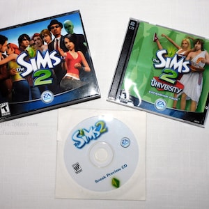 Puede incluir: La caja del videojuego Los Sims 2 con un fondo azul y un grupo de personas en la portada. La caja de la expansión Los Sims 2 Universidad con un fondo verde y dos personas en la portada. Un CD de vista previa para Los Sims 2.