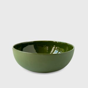 May include: A deep green ceramic bowl with a glossy finish. The bowl is round and has a slight lip.