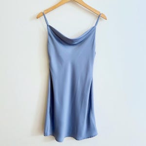 Peut inclure: Une robe de soir&eacute;e en satin bleu clair avec des bretelles fines et un col en V.