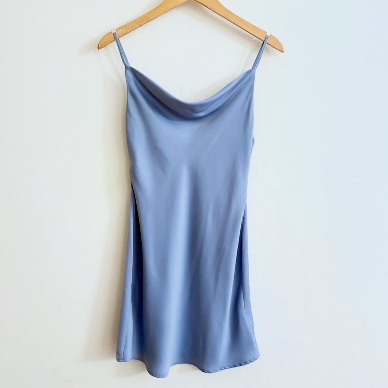 Peut inclure: Une robe de soir&eacute;e en satin bleu clair avec des bretelles fines et un col en V.
