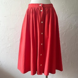 May include: A red midi skirt with a button-up front and a gathered waist.