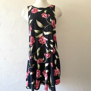 May include: A sleeveless black dress with a floral print of pink roses and green leaves.
