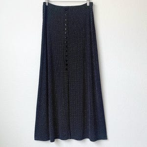 May include: A black maxi skirt with white polka dots and a button front closure.