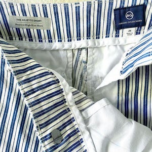May include: White and blue striped shorts with a white waistband and a label that reads "THE JULIETTE SHORT Nautical High-Rise Short (AG) ADRIANO GOLDSCHMIED 24 MADE IN CHINA"